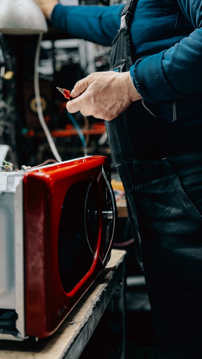 Technician repairing a microwave oven